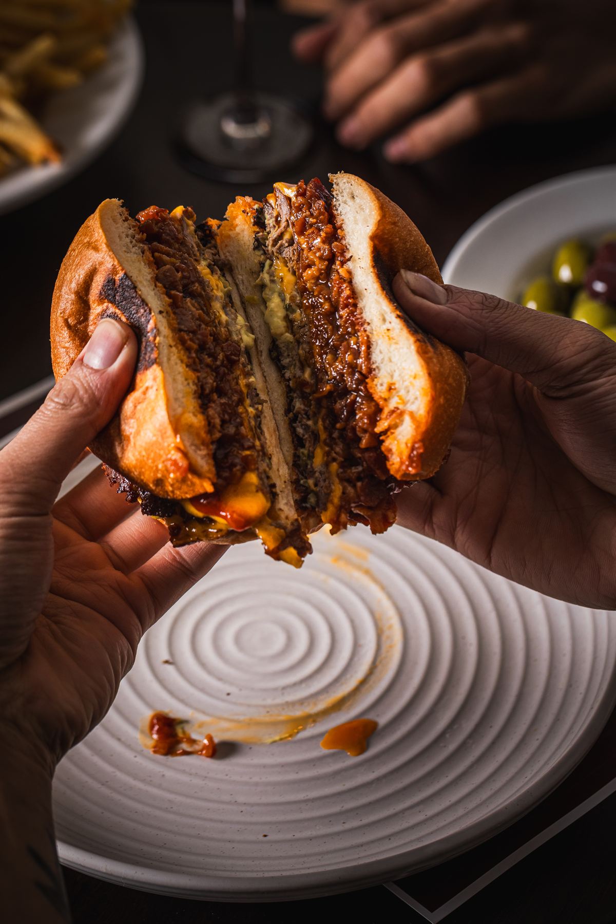 The Burger Victoria torn in half — smashed patties, cheese and bacon jam