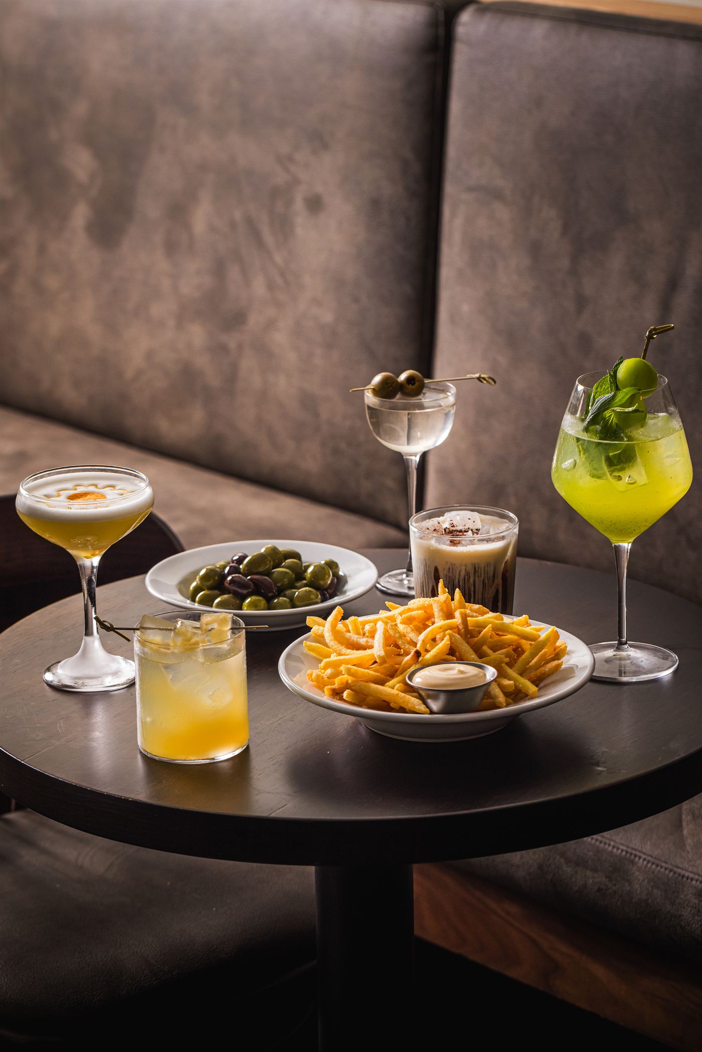 Cocktails, olives and shoestring fries on a table at Bar Victoria, Darlinghurst