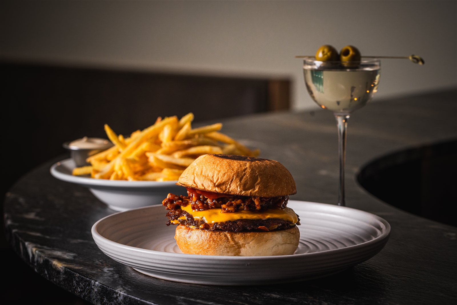 The Adult Happy Meal at Bar Victoria — the Burger Victoria, a bowl of shoestring fries and a martini on the dark marble bar